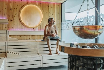 Man looking through window while sitting at finnish sauna