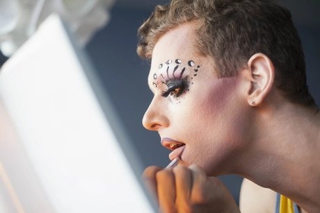 Young man applying drag makeup