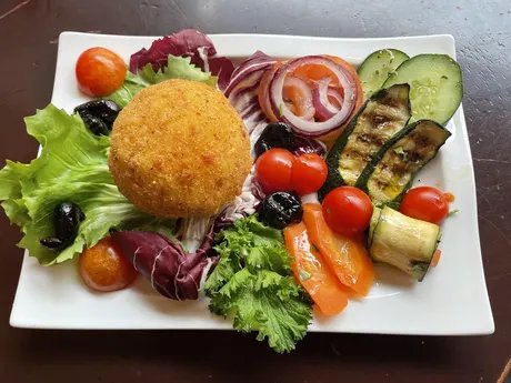 Arancino mit Porchetta, Primo Sale-Käse und Safran, mit vegetarischer Antipasti-Mix