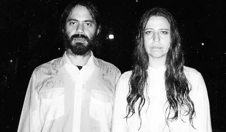 Schwarz-weiße Nauhaufnahme der Jazz-Musiker M. Takara & Carla Boregas, die bei Regen in die Kamera blicken.