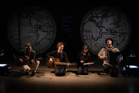 Vier Musiker:innen spielen Gitarre, Bassgitare, Xylophon und Akkordeon.