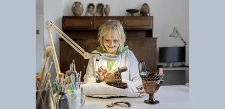 Restauratorin Anke Kobbe bei der Bearbeitung eines Gesichts-Kantharos aus dem 6. Jhd. v. Chr. im Alten Museum.