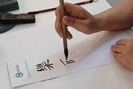 Teilnehmer:innen dieses Mitmach-Angebots können eine chinesische Kalligrafie ihres Namens mit nach Hause nehmen.