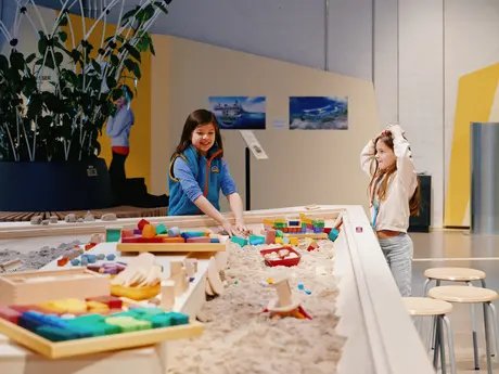Mit kinetischem Sand und bunten Bauelementen können Kinder und Erwachsene selbstständig oder in Workshops an ihren Ideen für eine lebenswerte Stadt der Zukunft bauen.