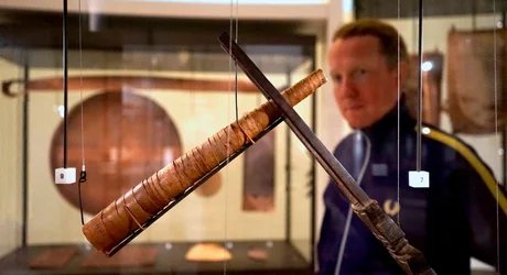 Besucher vor einer Vitrine mit Zigarrenhalter und Zigarre im Ethnologischen Museum