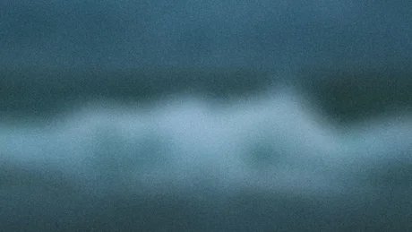 Unscharfe Wellen vor einem dunklen Himmel.