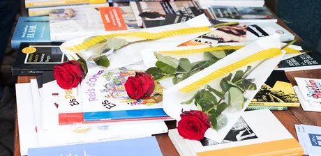 Rosen und Bücher auf einem Tisch liegend