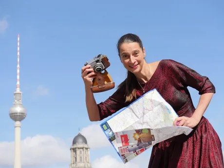 Christine Lander posiert mit Kamera und Stadtplan vor dem Berliner Fernsehturm. Christine Lander posiert mit Kamera und Stadtplan vor dem Berliner Fernsehturm.
