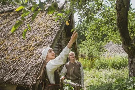 Zwei Frauen im Garten des Freilichtmuseums beim Ertasten eines Baumzweiges