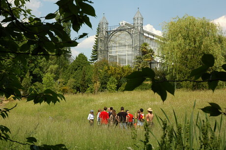 Führung im Botanischen Garten, im Hintergrund Mittelmeergewächshaus