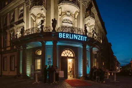 Das Museum bei Nacht von außen mit blauer Leuchtschrift, auf der BERLINZEIT steht