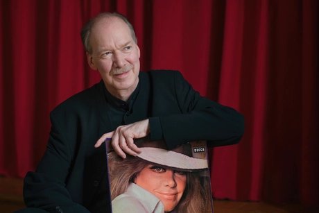 Carl Martin Spengler in der Hand ein Schallplattencover mit dem Portrait von Hildegard Knef haltend