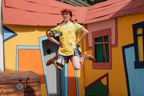 Pippi Langstrumpf springt vor ihrer Villa in die Höhe