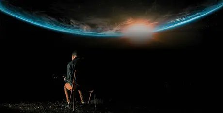 Zu sehen ist Chris Hanson von hinten, während er Gitarre spielt. Im Hintergrund ist ein Bild eines Sonnenaufgangs auf der Erde aus dem All zu sehen.