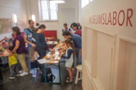 Der Blick ins Museumslabor zeigt eine Gruppe beim Gestalten kreativer Drucke