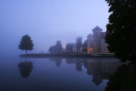 Schloss Rheinsberg in der Dämmerung mit Blick über den See