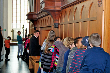 Kinder hören den Klängen der Orgel im Museum Nikolaikirche zu.