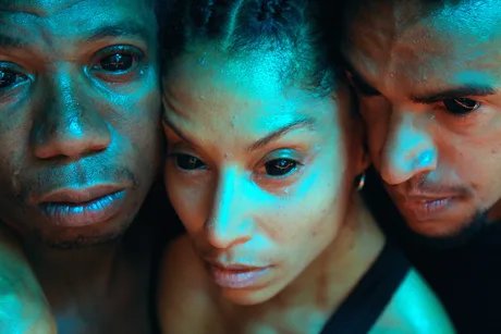 Close up auf die Gesichter von drei People of Colour. Sie haben tote Augen und blicken traurig.