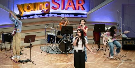 Jugendliche auf der Bühne singen und spielen Instrumente