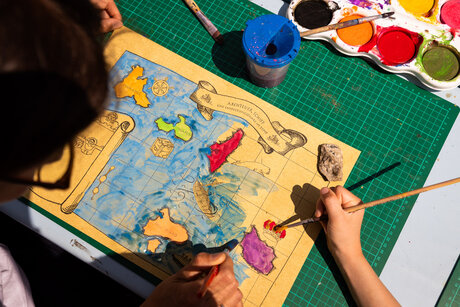 Eine Landkarte wird von einem Kind koloriert.