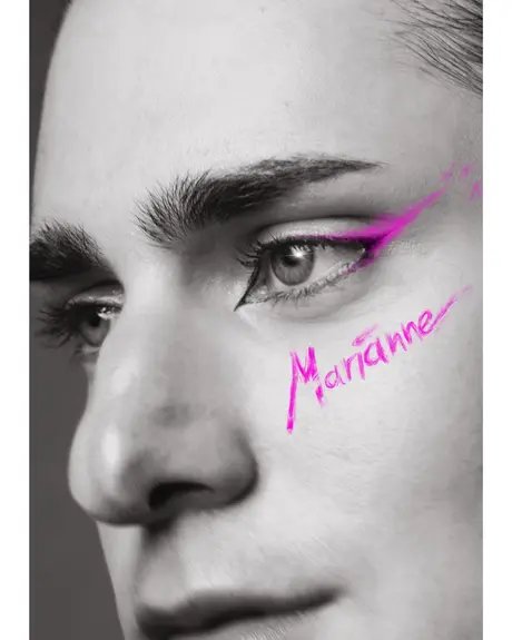 Nahaufnahme eines Gesichts in Schwarz-Weiß. Ein Auge ist mit auffälligem, pinkem Eyeliner geschminkt, daneben steht in pinker, handschriftlicher Schrift das Wort ‚Marianne‘.