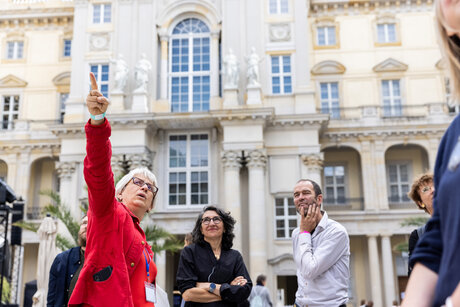 Eine Stadtführerin beschreibt den Gästen die Fassade des Humboldt Forums.