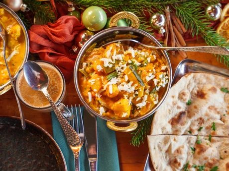 Amrit Restaurant – Curry-Gericht mit Naan und weihnachtlicher Dekoration