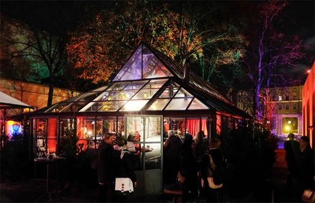 Glaspalast Schankhalle Pfefferberg – Außenansicht bei Nacht mit Gästen