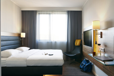 Doppelzimmer mit Doppelbett und Fernseher im Moxy Hotel Ostbahnhof
