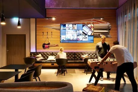 Junge Menschen am Kicker spielen im Moxy Hotel Ostbahnhof