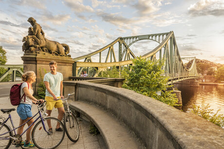 Bicycle tour man and woman near Glienicke Bridge in Berlin