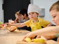 Kinder schneiden Gemüse in der Küche des Kindermuseums unterm Dach