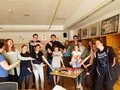 Jugendliche stehen lachend um einen Tisch herum