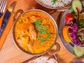 Amrit Restaurant – Curry-Gericht mit Reis und Salat