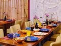 Amrit Restaurant – Gedeckte Tafel vor Bambuswand und Steinrelief