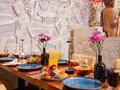 Amrit Restaurant – Gedeckte Tafel vor Steinrelief mit Buddha-Statue