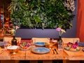 Amrit Restaurant – Gedeckter Tisch mit Pflanzenwand