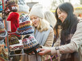 Las mujeres compran gorras en el mercado de Navidad