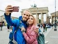 Stylish Young Couple Take A Selfie In Front Of Local Architecture