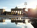 Brandenburger Tor in Berlin: Spiegelung des Brandenburger Tors in einer Pfütze