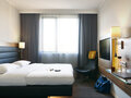 Doppelzimmer mit Doppelbett und Fernseher im Moxy Hotel Ostbahnhof
