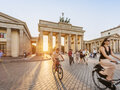 Berliner Sehenswürdigkeit Brandenburger Tor im Sonnenlicht mit Radfahrern