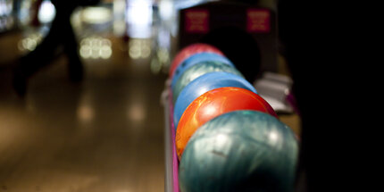 Colorful bowling balls on rack on bowling lane