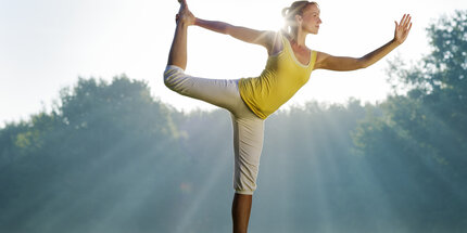 Frau praktiziert Yoga im Park