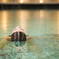 A woman relaxes in the pool of a day spa