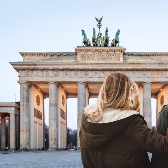 Pareja joven haciendo turismo en la Puerta de Brandemburgo en invierno