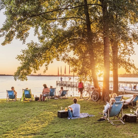 Entspannte Atmosphäre auf Liegestühlen am Berliner Müggelsee bei Sonnenuntergang