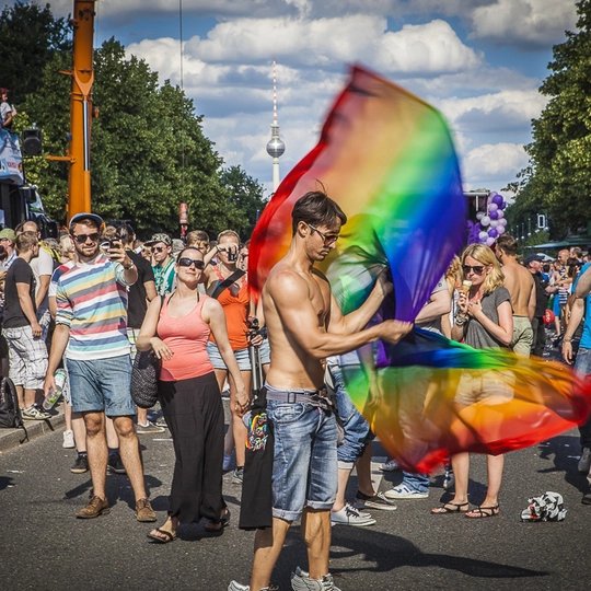 Menschen mit Regenbogenfahne auf dem CSD in Berlin