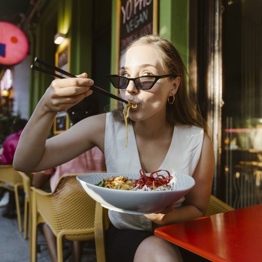 Frau_isst_im_Restaurant_mit_Stäbchen_asiatisch