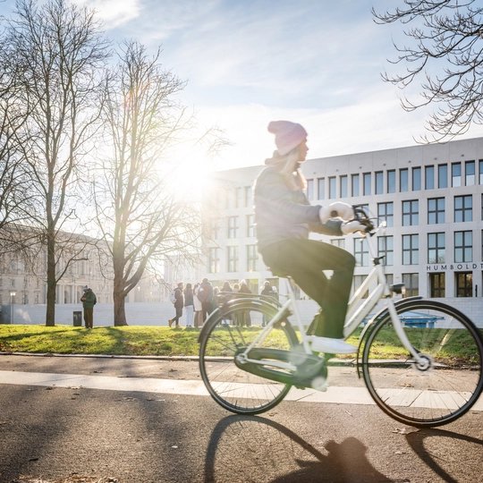 Radfahrerin vor dem Humboldtforum in Berlin im winterlichen Sonnenschein